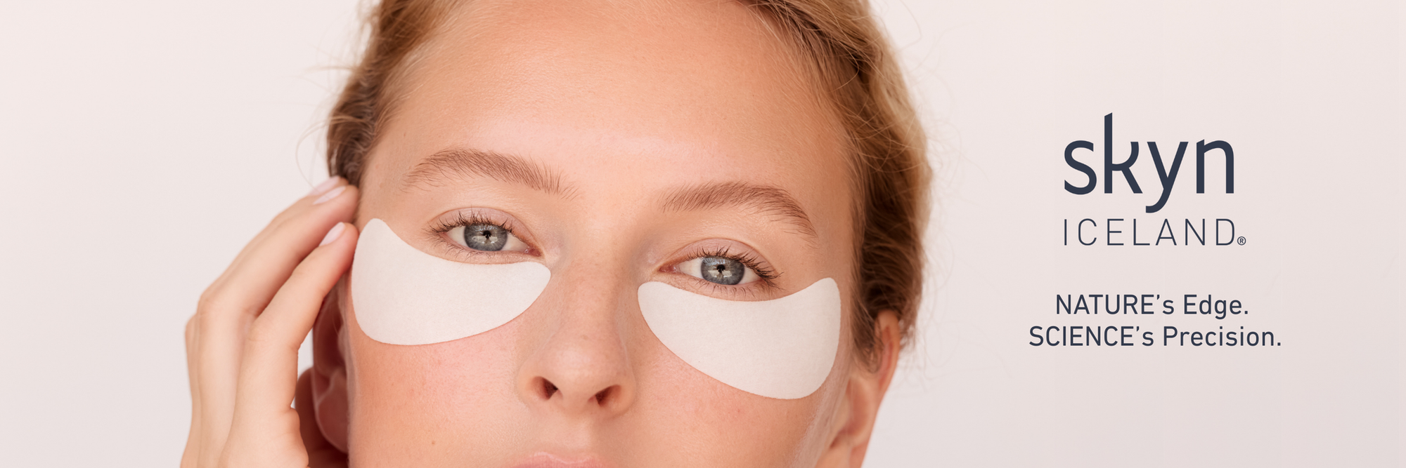 Person wearing eye patches with Skyn Iceland logo in the background