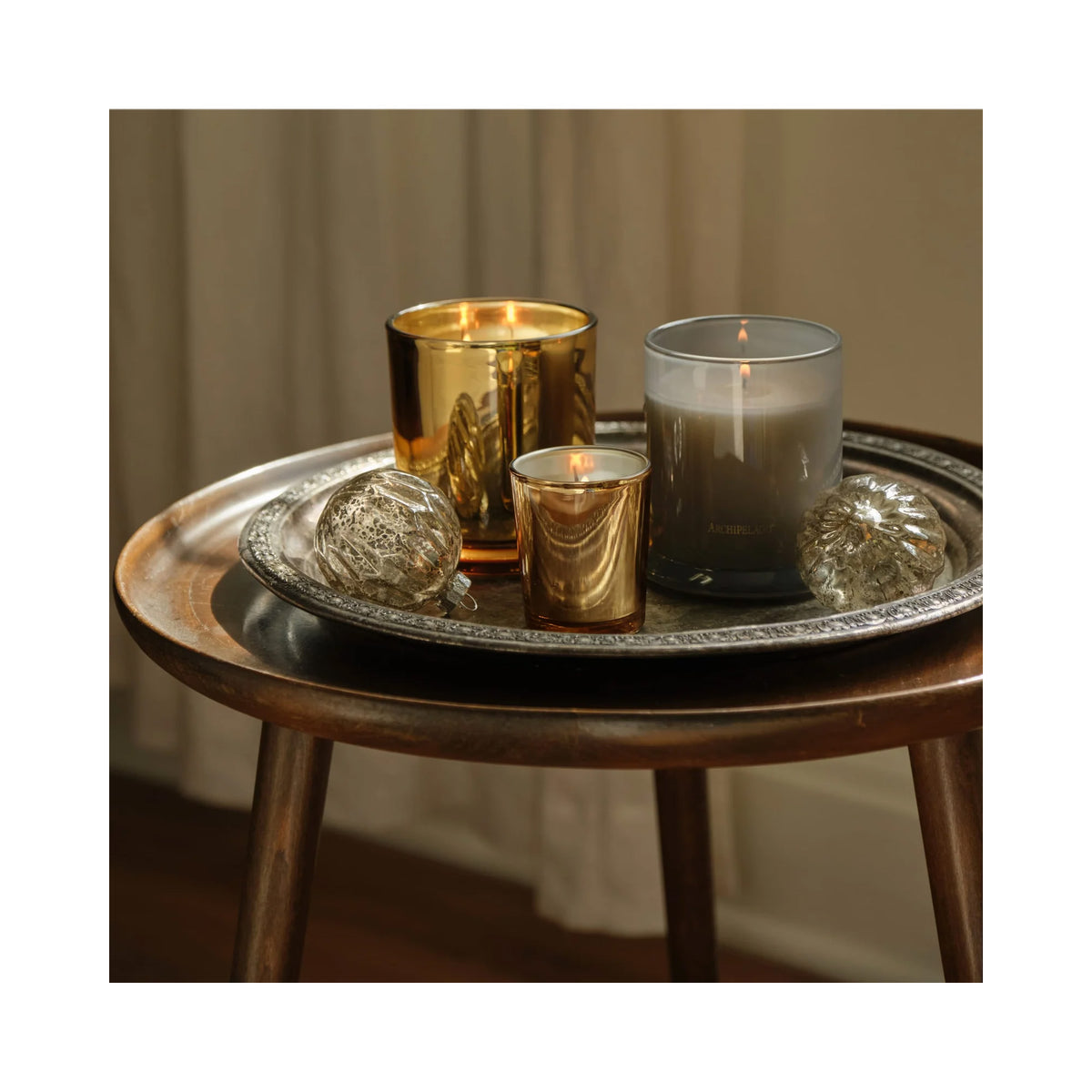 Archipelago Silver Balsam Credenza Candle, three candles lit on a table, image 46265550143638