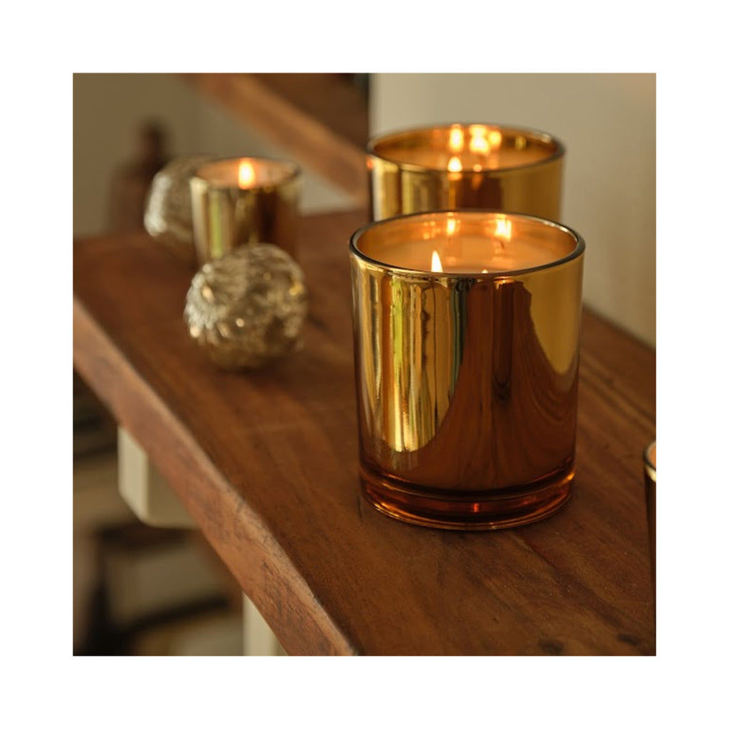Archipelago Silver Balsam Credenza Candle lit on mantle, gold glass jar  thumbnail 2